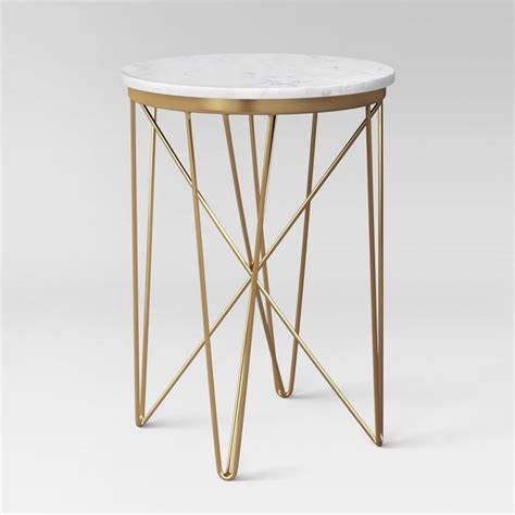 a white marble top side table with gold metal legs