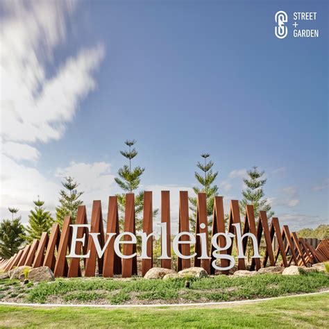 a sign that says evergreen on it in front of some trees and grass with ...