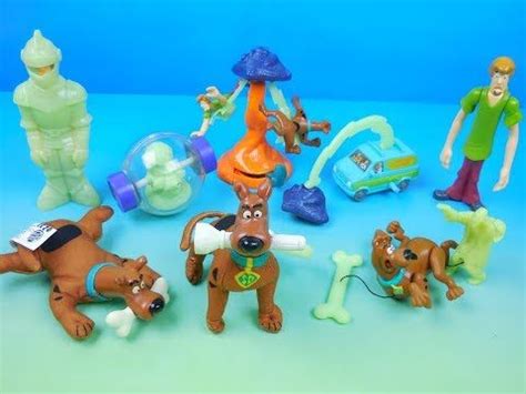 a group of toys that are on a blue tablecloth with one dog laying down ...