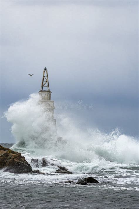 Tall Lighthouse in the Stormy Ocean Under Dark Storm Clouds Stock Photo ...