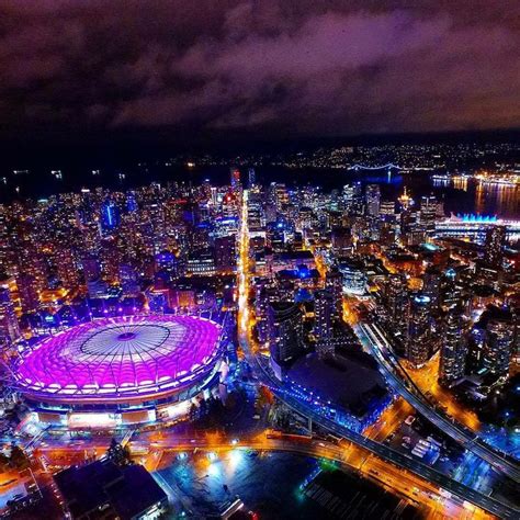 an aerial view of the stadium and surrounding city lights at night ...