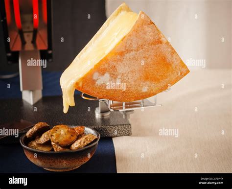 Raclette cheese with roasted potatoes Stock Photo - Alamy