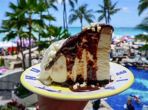 a piece of cake sitting on top of a yellow and white plate next to the ocean