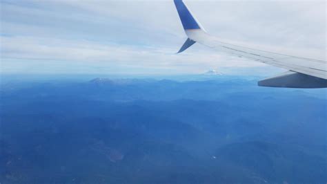 airplane flying with mountains and landscape and clouds 7709851 Stock Photo at Vecteezy