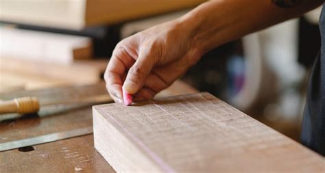 Faceless joiner drawing with chalk on wooden block · Free Stock Photo