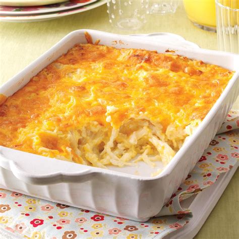 a casserole dish with cheese and onions in it on a place mat next to plates