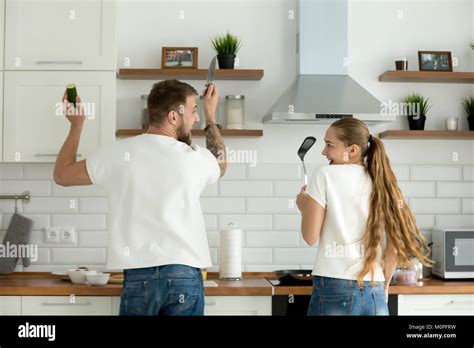 Funny couple having fun cooking in kitchen together, rear view Stock ...