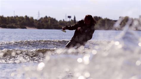 Wake boarding rider enjoy training. Rider surfing between waves on water board in slow motion ...