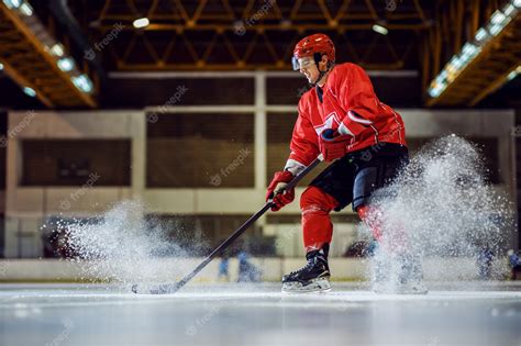 Premium Photo | Full length of fearless hockey player skating and trying to make a score. Hall ...