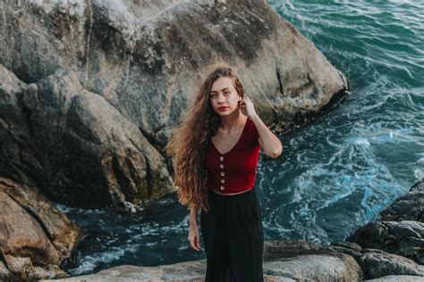 Young woman relaxing on rocky seashore · Free Stock Photo