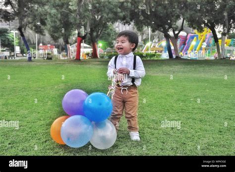 Happy Boy With Balloons Standing On Park Stock Photo - Alamy