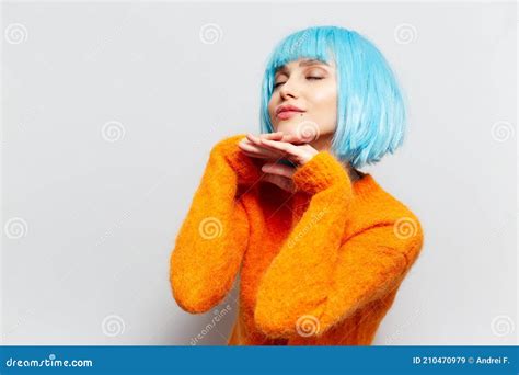 Portrait of Young Girl with Blue Hair in Orange Sweater, Holding Hands ...