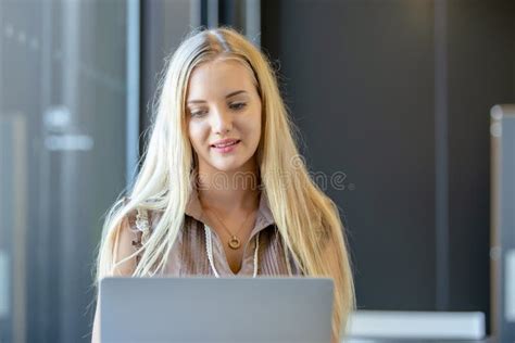 Beautiful Woman with Blond Hair Using Computer Laptop at Office Table ...