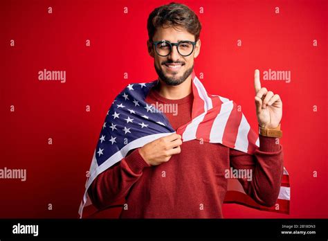 Young man wearing glasses and United States of America flag over ...