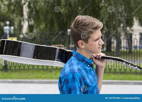 Young Guy with an Acoustic Guitar on the Nature is Resting. Stock Photo ...