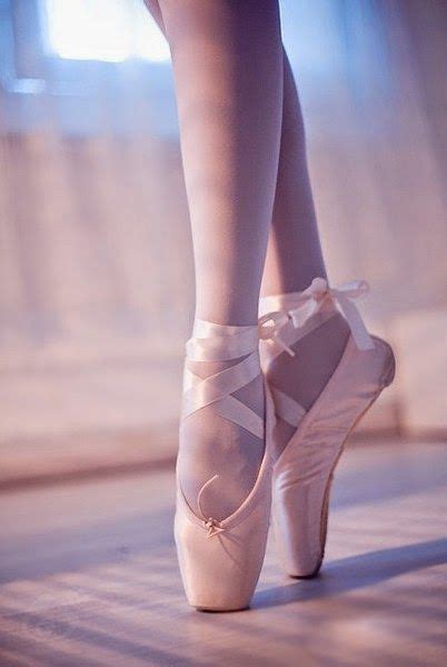 a close up of a person's feet wearing ballet shoes