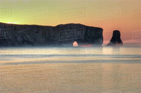 Misty sunrise at Perce Rock, Quebec - Stock Photo - Dissolve