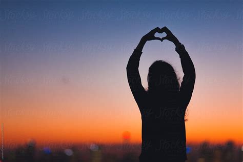 Woman In Silhouette Making Heart Shape With Hands On Sunset | Stocksy United