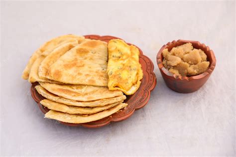 Premium Photo | Desi breakfast omelet halwa and paratha served in dish isolated on background ...