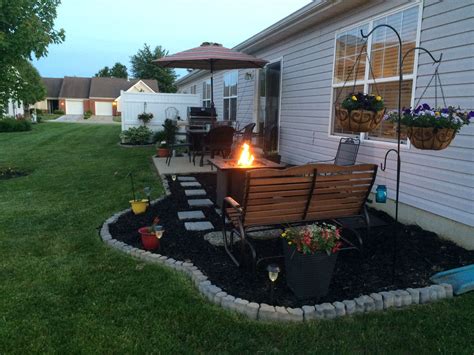 Low cost patio extension, using mulch, paver steps, and concrete edgers, featuring a fire table ...