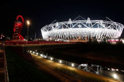 the olympic stadium is lit up at night