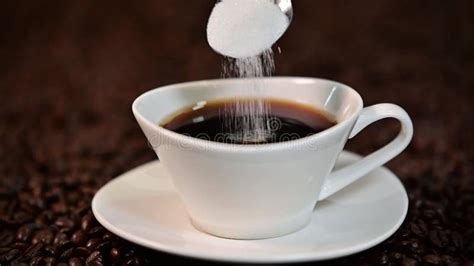A Spoon of White Sugar Pouring into a Cup Full of Black Coffee in Slow Motion Stock Video ...