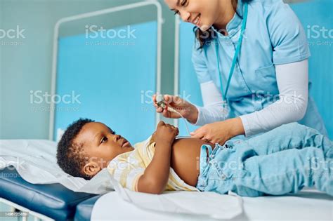 Happy Nurse Putting Ecg Electrode On Black Boys Chest During Medical Examination At The Clinic ...