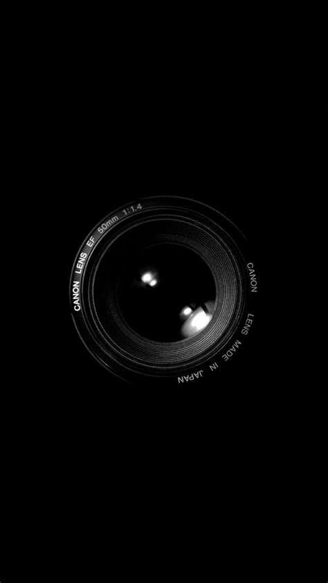 a black and white photo of a camera in the dark with its lens pointed up