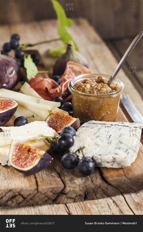 Cheese platter with fruits and fig mustard stock photo - OFFSET