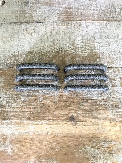 four metal objects sitting on top of a wooden floor