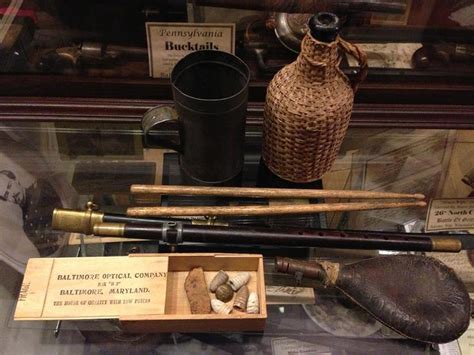 an assortment of items on display in a glass case with wooden spoons and other objects