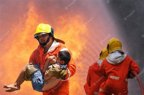 Premium Photo | Firefighter holding child boy to save him in fire and smokefiremen rescue the ...