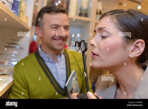 female client trying magnifying glasses at retail store Stock Photo - Alamy