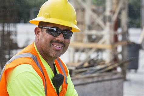 Hispanic worker smiling at construction site stock photo