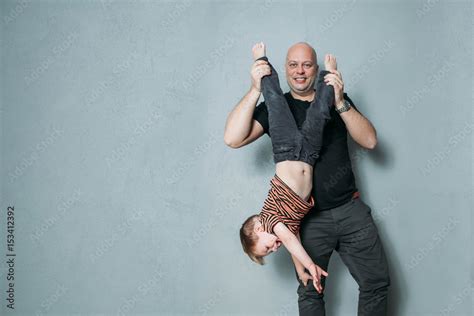 funny young dad keeps his son's legs upside down Stock Photo | Adobe Stock