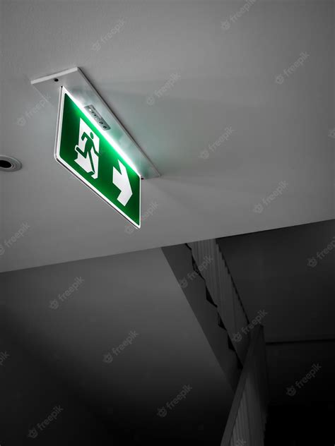 Premium Photo | Fire exit sign Green emergency exit sign hanging from ...