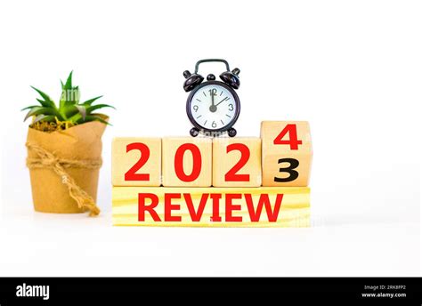 2024 review new year symbol. Businessman turns a wooden cube and changes words Review 2023 to ...