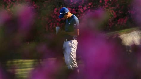 Collin Morikawa makes notes on the No. 13 green during the first round ...