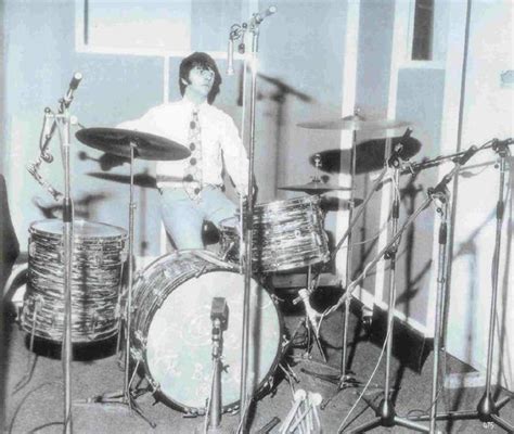 a man sitting in front of a drum set