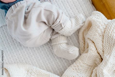 Baby's legs in warm socks and pants on a white plaid Stock Photo ...