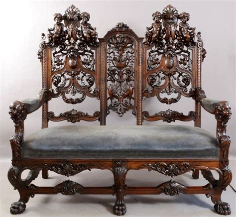 an ornately carved wooden bench with blue upholstered seat and back ...