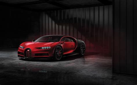 a red bugatti is parked in a dark room