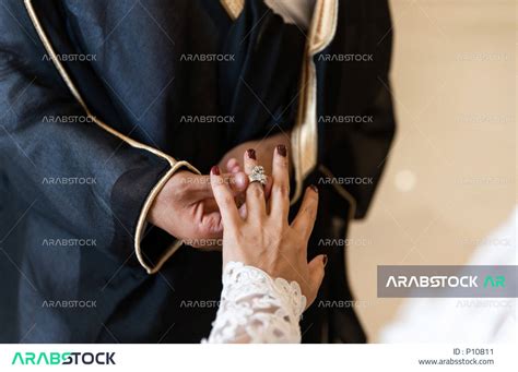 Two Saudi grooms at their wedding, the groom and bride are exchanging ...