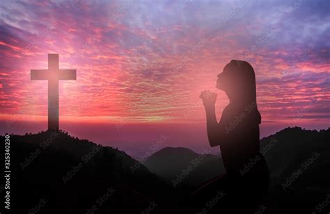 Foto de Silhouette of woman kneeling and praying tp god over beautiful sunrise do Stock | Adobe ...