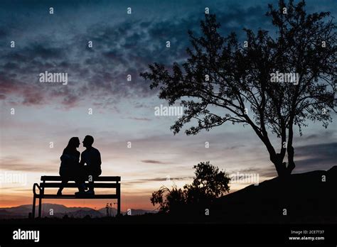 Silhouette couple sitting bench sunset bench hi-res stock photography ...