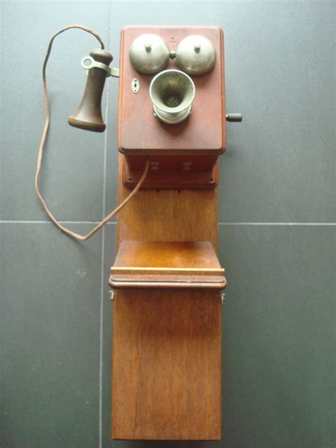 Very old wall phone with horn (+/-1900) made of wood. Attached to an ...