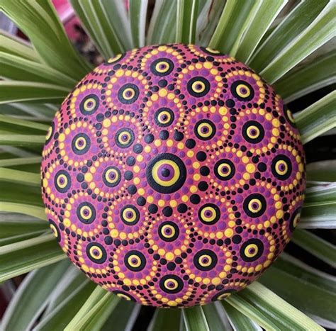 a colorful rock sitting on top of a green plant