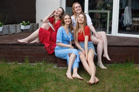 Group of Young Smiling Gorgeous Barefoot Women Sitting on Wooden ...