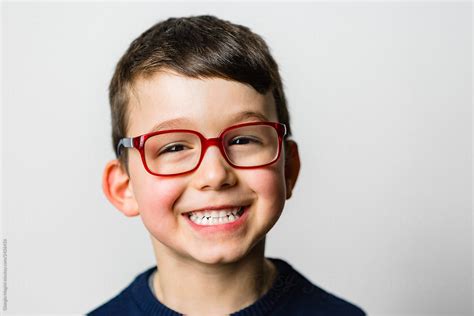 "Studio Portrait Of A Smiling Child With Glasses" by Stocksy Contributor "Giorgio Magini" - Stocksy