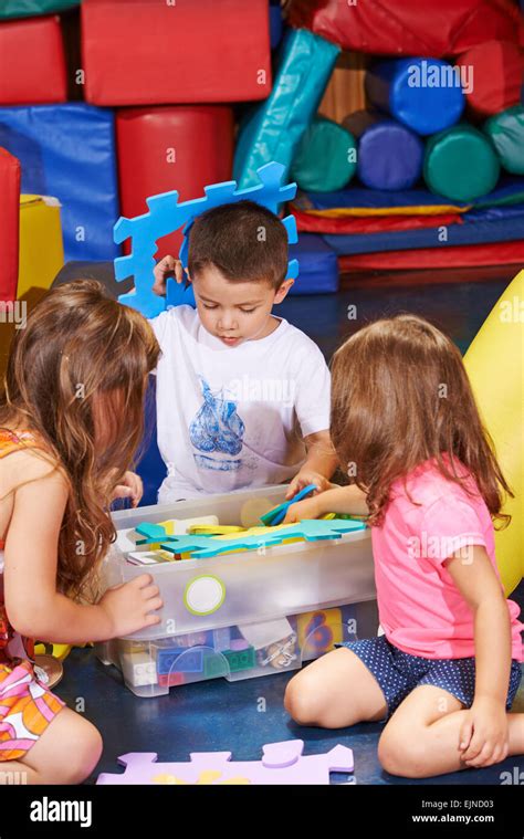 Children cleaning up toys in a box in kindergarten Stock Photo - Alamy